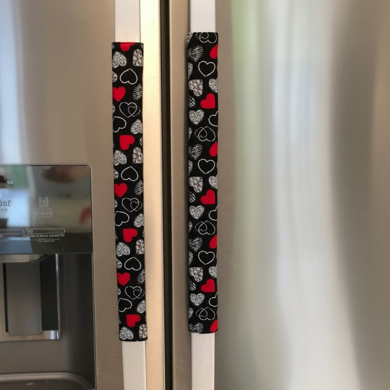 Fridge handles with heart patterned covers on a refrigerator.