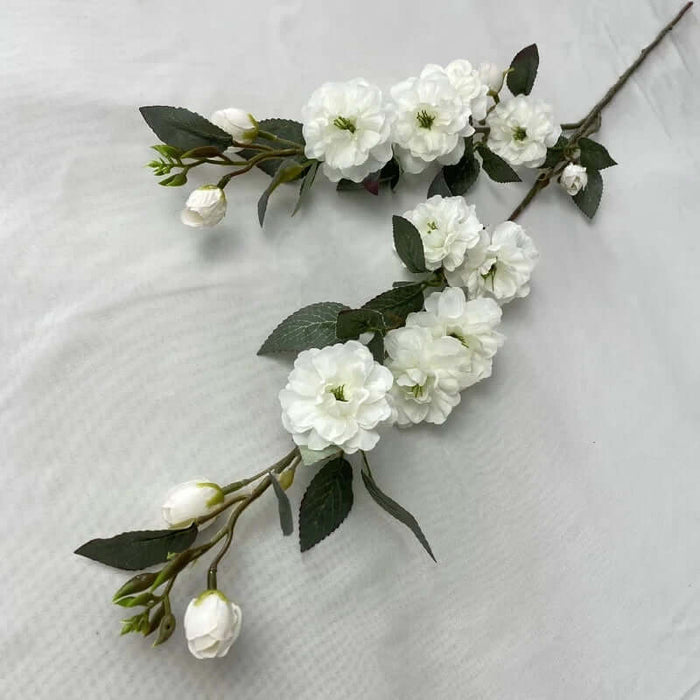 Artificial Camellia stems with white flowers and green leaves, perfect for elegant floral arrangements indoors or at events.