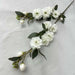 Artificial Camellia stems with white flowers and green leaves, perfect for elegant floral arrangements indoors or at events.