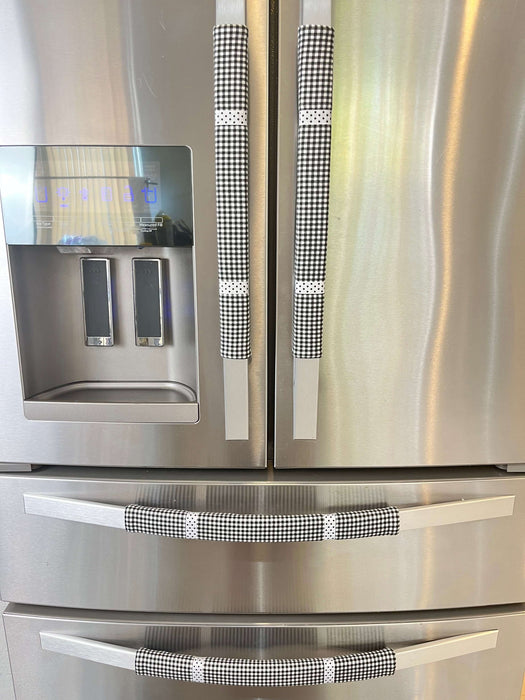 Black and white buffalo plaid appliance handle covers on refrigerator handles, enhancing kitchen decor and preventing stains.