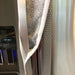Grey and white gerbera daisy handle covers on stainless steel refrigerator, adding style and protection.