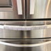 Grey and white gerbera daisy handle cover on a stainless steel refrigerator door handle.