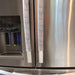 Grey and white gerbera daisy handle covers on stainless steel refrigerator door handles.