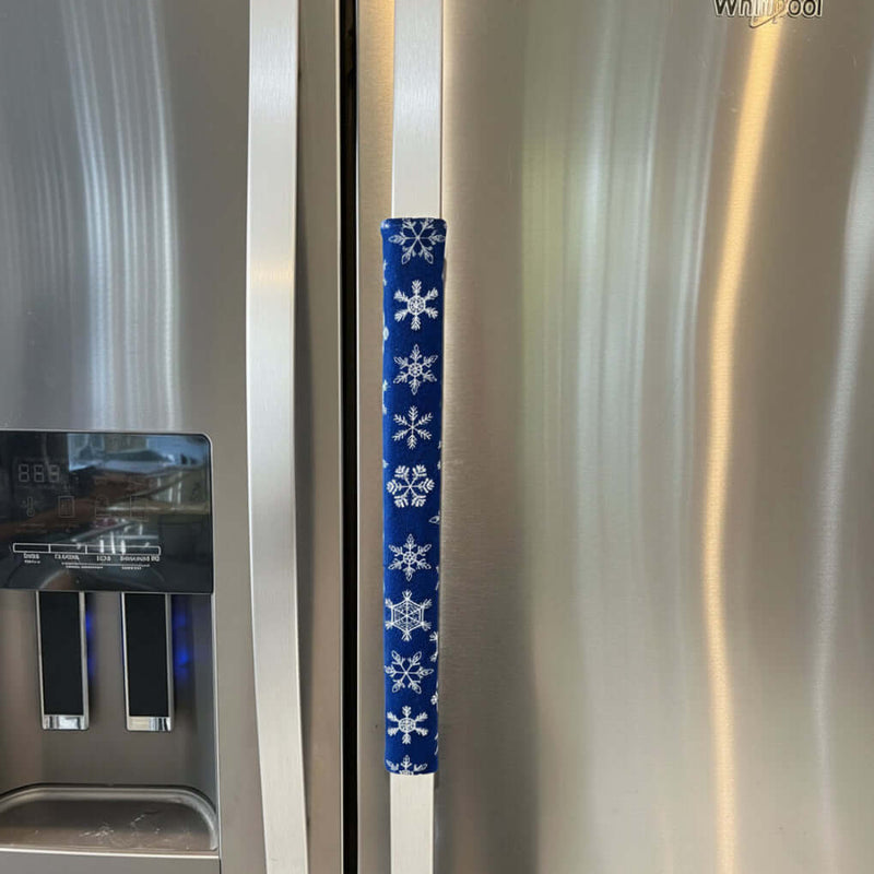 Stainless steel appliance with a decorative blue handle cover featuring white snowflakes.