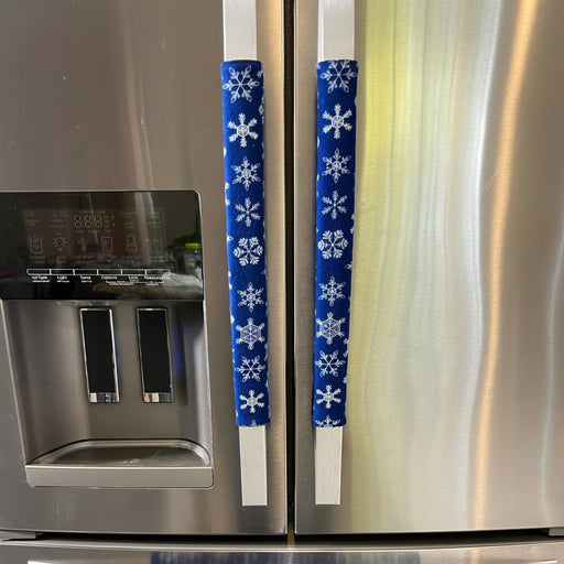 Stainless-steel refrigerator with blue-and-white snowflake-patterned handle covers.