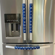 Stainless steel refrigerator with blue snowflake-patterned handle covers.