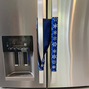 Blue snowflake-patterned handle cover draped over a fridge handle