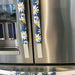 White and yellow daisy design on blue appliance handle covers for modern kitchen décor.