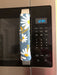 White and yellow daisy appliance handle cover on microwave, enhancing decor and protecting handles from scratches.