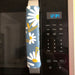 White and yellow daisy appliance handle cover on microwave, enhancing decor and protecting handles from scratches.