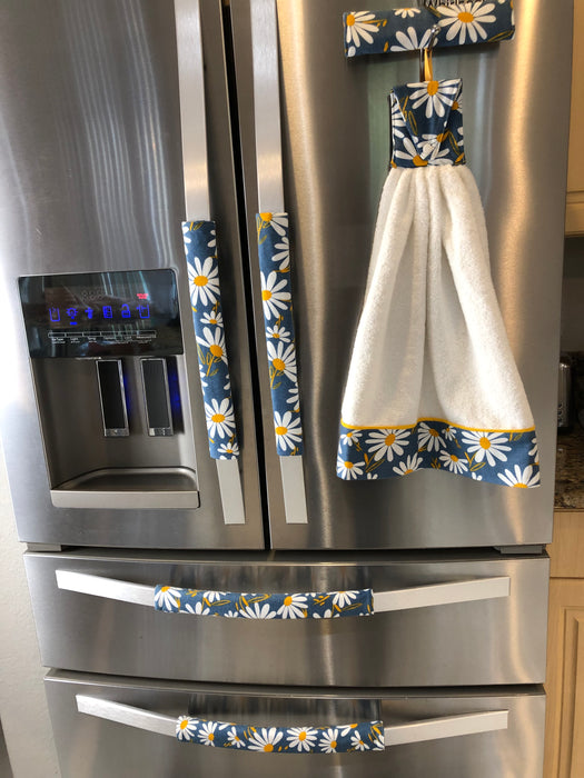 Stylish blue appliance handle covers set with towel featuring white and yellow daisies, adding modern décor and protection