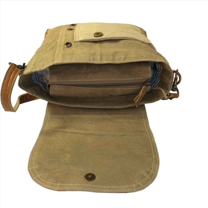 Brown leather bag with a strap on a white background