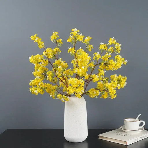 Artificial osmanthus tall stems in a white vase adding elegance to a modern room decor.