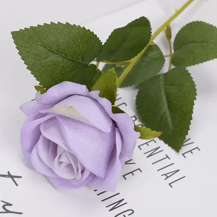 Artificial real-touch rose flower stems with lavender bloom and green leaves on elegant background.