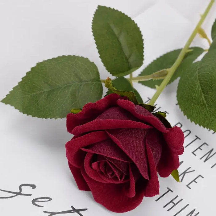 Artificial real-touch rose flower stems with lush green leaves on decorative background.