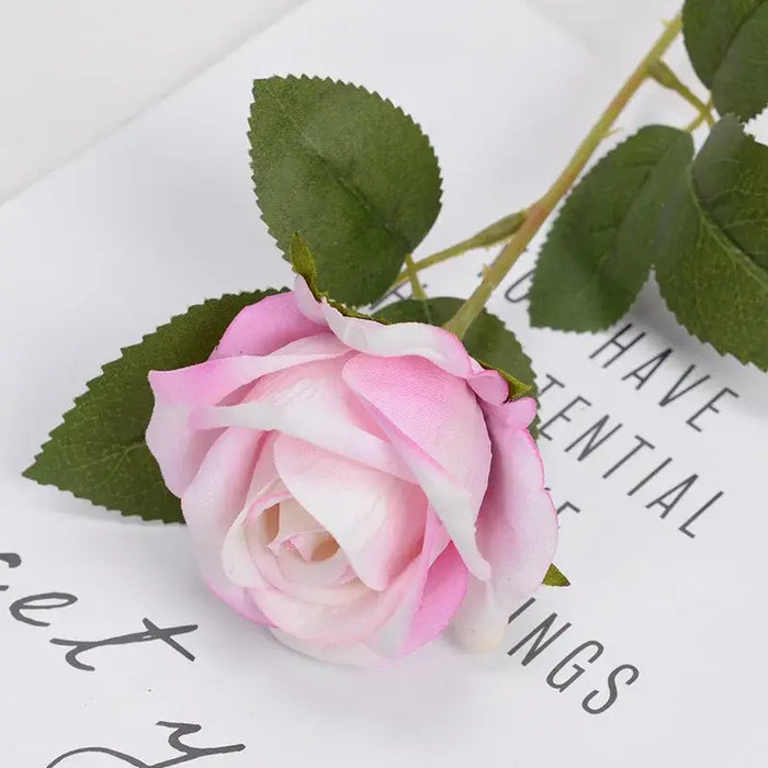 Artificial Real-Touch Rose Flower Stems with pink blooms and lush green leaves on a decorative background.