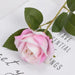 Artificial Real-Touch Rose Flower Stems with pink blooms and lush green leaves on a decorative background.