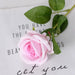 Artificial real-touch rose flower stems showcasing a lifelike pink rose with green leaves on a decorative background.