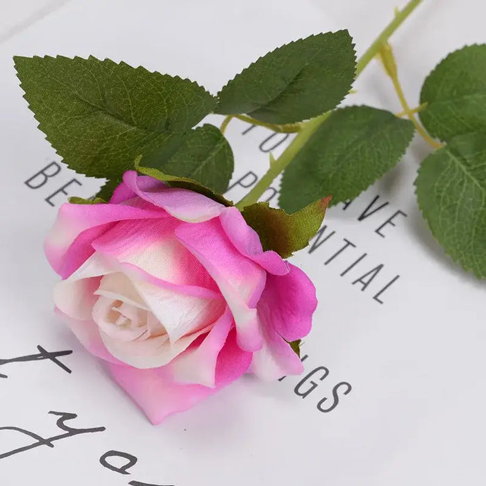 Artificial real-touch rose flower stems with pink blooms and green leaves on a decorative background.