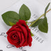 Artificial real-touch rose flower stems with vibrant red blooms and lush green leaves on a white surface.