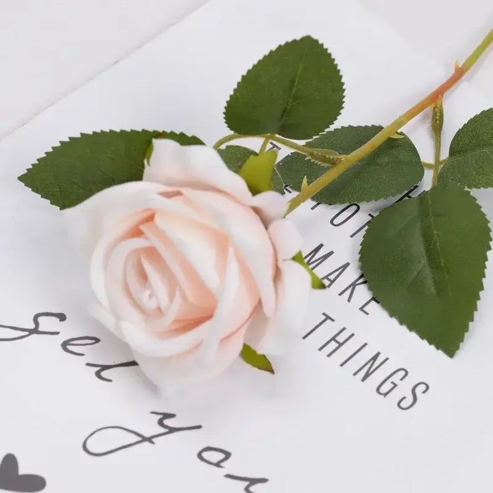 Artificial real-touch rose flower stems with pink blooms and green leaves on decorative background.