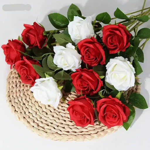 Artificial real-touch rose flower stems in red and white arranged in a woven basket with green leaves.