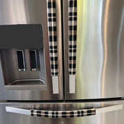 Stainless steel refrigerator with black and cream checkered handle covers