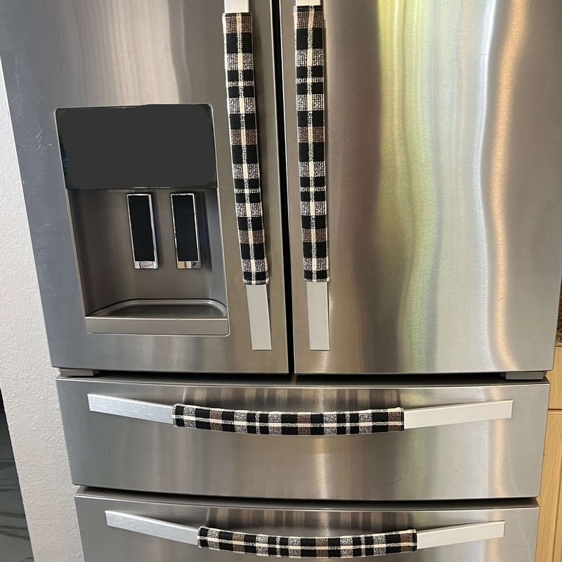 Stainless steel refrigerator with black and cream checkered handles in a kitchen setting