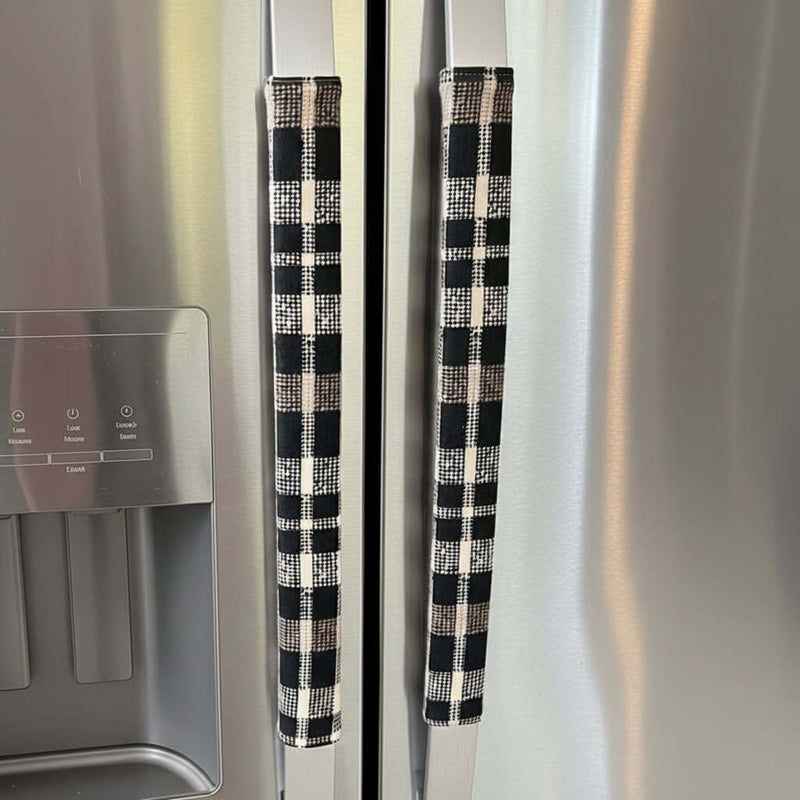 Black and cream checkered refrigerator handles on a stainless steel refrigerator.