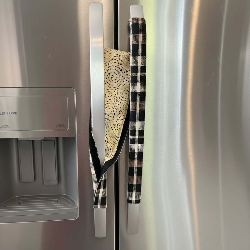 Two kitchen fridge handle covers on a stainless steel refrigerator door, showing the reverse.