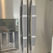Buffalo plaid appliance handle covers in black and white on a modern refrigerator, enhancing kitchen decor and functionality.