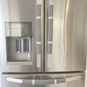Buffalo plaid appliance handle covers in black and white on a stainless steel refrigerator.