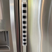 Black and white checkered handle cover on a stainless steel refrigerator door.