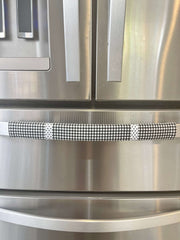 Buffalo plaid appliance handle covers on a stainless steel refrigerator, enhancing kitchen aesthetics with black and white design.