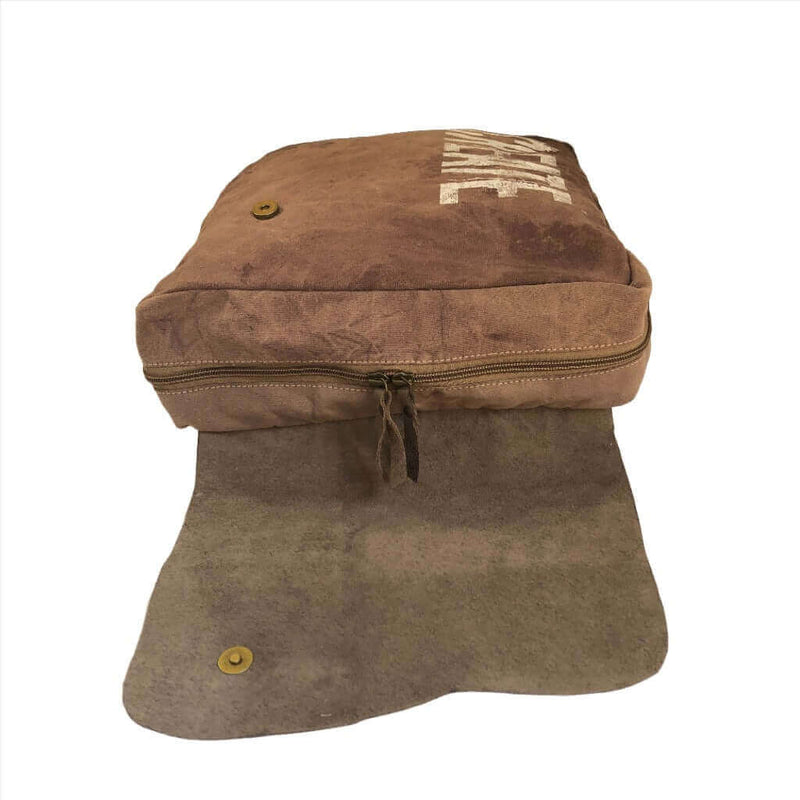 Canvas and leather backpack with zipper and flap design, showcasing rustic charm and spacious interior.