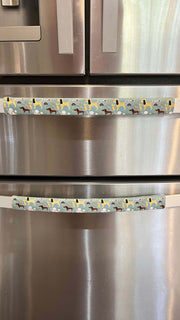 Cute puppy print on appliance handle covers on stainless steel refrigerator.