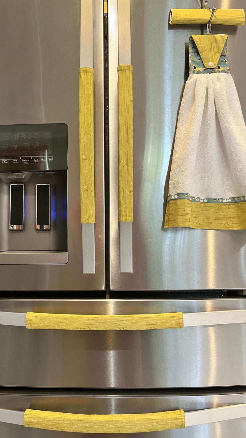 Cute puppy print on appliance handle covers on a refrigerator for playful kitchen decor.