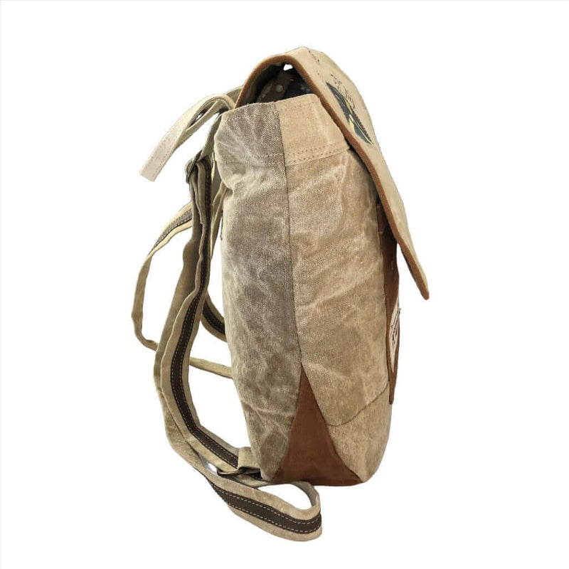 Eco-friendly canvas backpack side view showing upcycled materials and adjustable straps.
