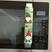Gnomes on The Green Christmas Appliance Handle Covers on a refrigerator handle, festive kitchen decor for the holiday season.