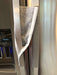 Grey and white gerbera daisy handle covers for kitchen appliances on a refrigerator door.