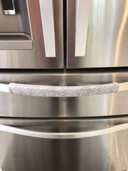 Grey and white gerbera daisy handle covers on stainless steel refrigerator door handle.