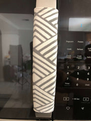 Geometric refrigerator handle covers in grey and white design on refrigerator, enhancing kitchen decor.