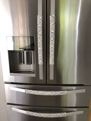 Geometric refrigerator handle covers in grey and white on a stainless steel refrigerator, adding style and functionality.