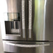 Geometric refrigerator handle covers in grey and white on a stainless steel refrigerator, adding style and functionality.