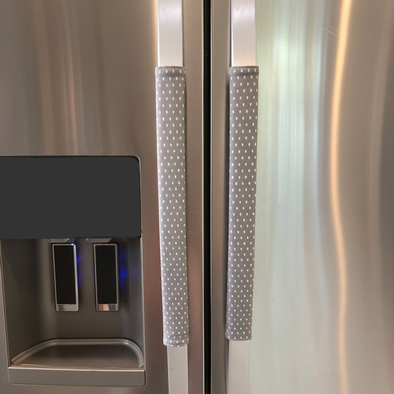 Grey and white polka-dot handle covers for stainless steel refrigerator handles.