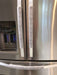 Grey and white gerbera daisy handle covers on stainless steel refrigerator handles.