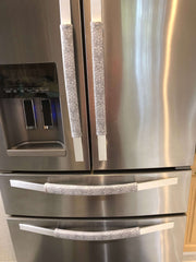 Grey and white gerbera daisy handle covers on stainless steel refrigerator doors for added protection and style.