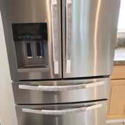 Grey and white gerbera daisy handle covers on stainless steel refrigerator doors for added protection and style.