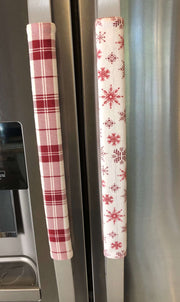 Rose pink snowflake appliance handle covers on kitchen refrigerator, adding a festive touch to kitchen decor.