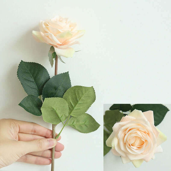 Latex real-touch artificial rose stems in soft peach color held by a hand with realistic leaves.